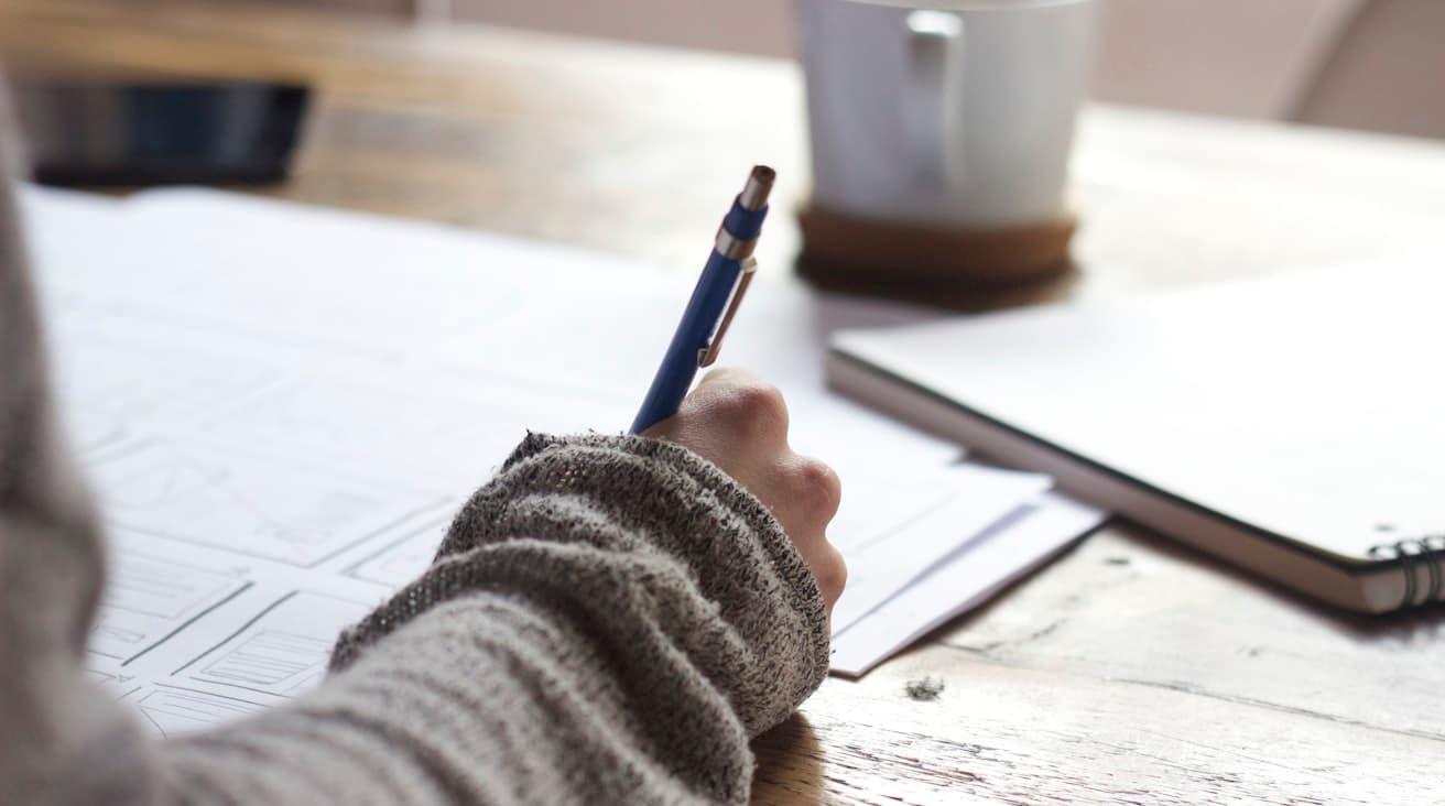 Une procédure rédigée à la main sur un carnet, plans de travail sur le bureau