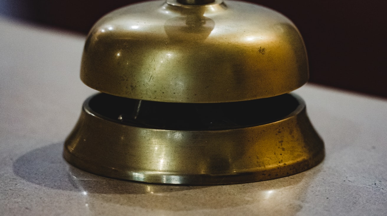 Une cloche dorée posée sur le comptoir d’une réception